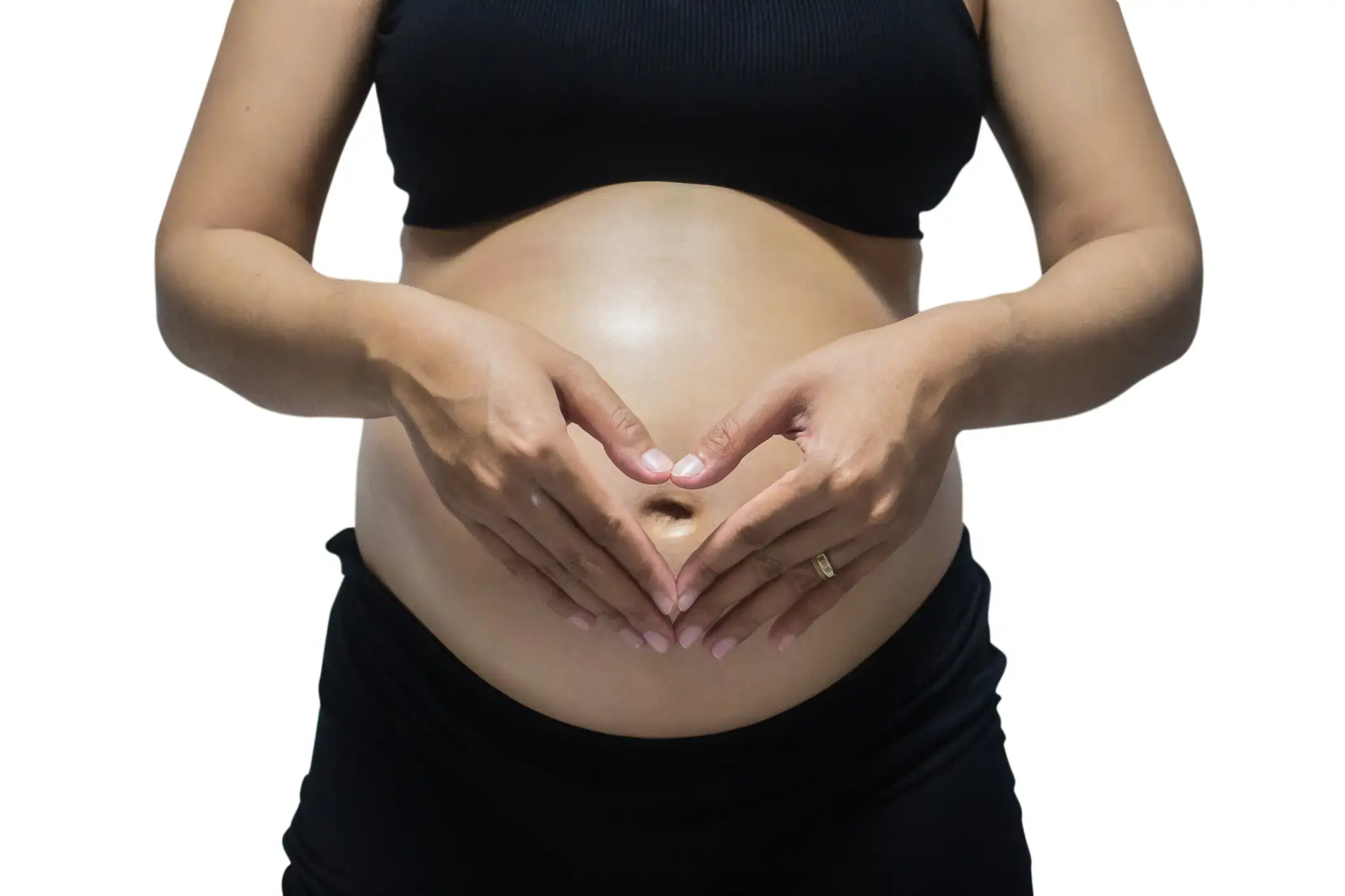 A pregnant woman making a heart shape with her hands, on her belly
